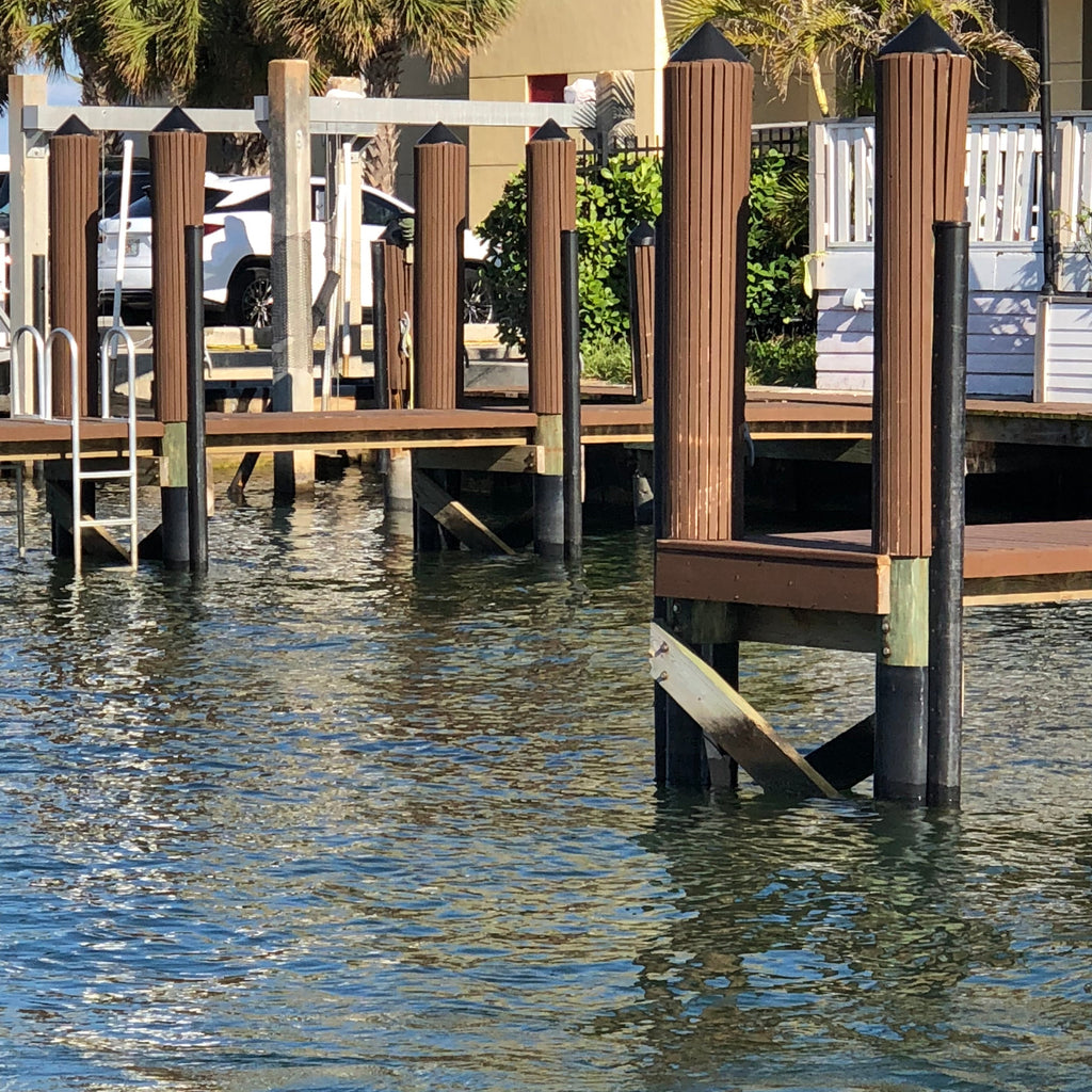 HDPE piling wrap installed on multiple dock pilings