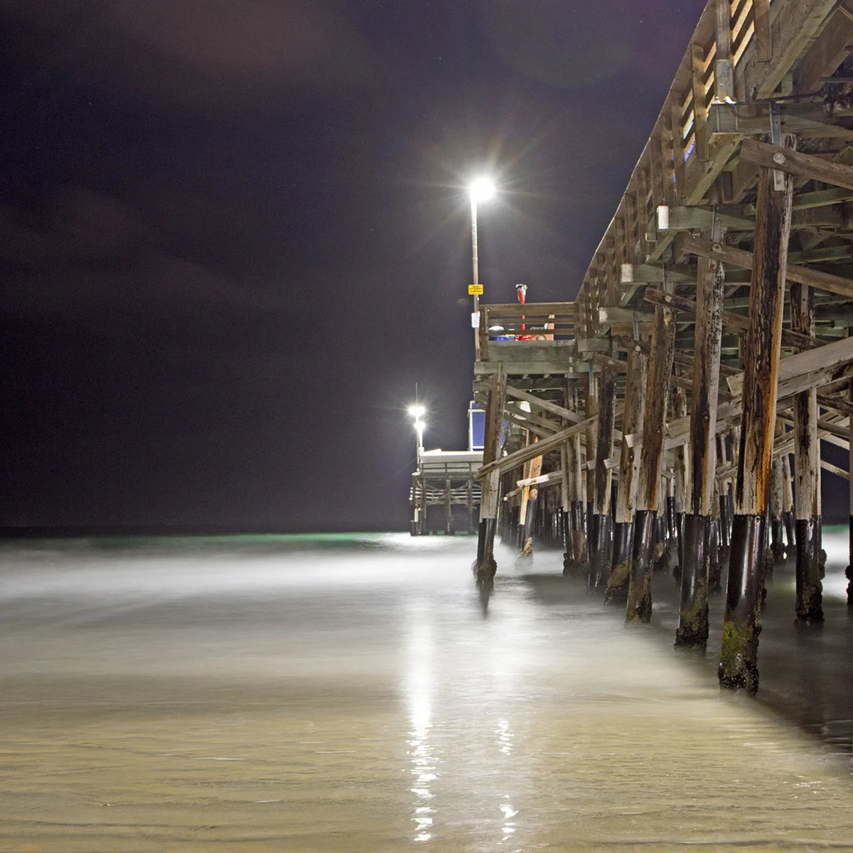Black HDPE surface wrap installed around timber dock pilings